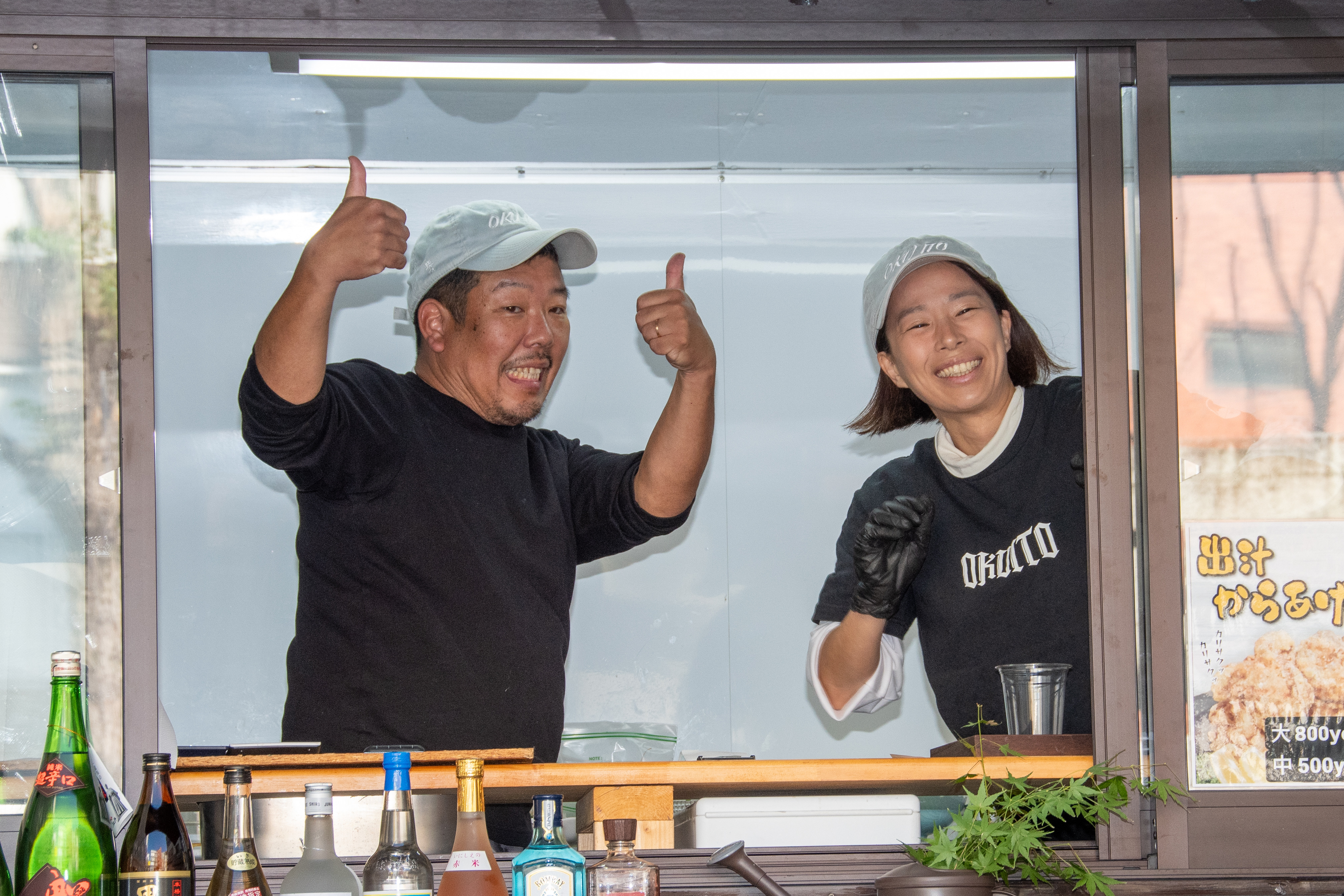 お客様に向けて笑顔で親指を立てる白和忠高とスタッフ